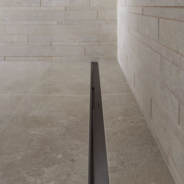 Voda odteka po elegantnem profilu iz nerjavečega jekla. Voda odteka po elegantnem profilu iz nerjavečega jekla.